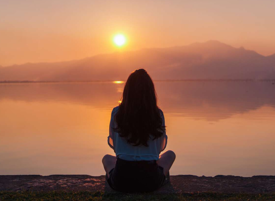 A girl watching serene sunset at Phayao Lake
